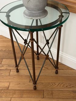 Creative Co-Op round bronze metal accent table with a glass top.