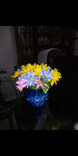 Blue low round vase includes artificial flowers