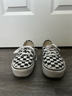 These Vans Authentic sneakers feature a classic black and white checkerboard pattern on the canvas upper.