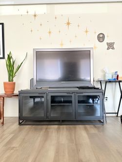 Black metal media console with glass doors