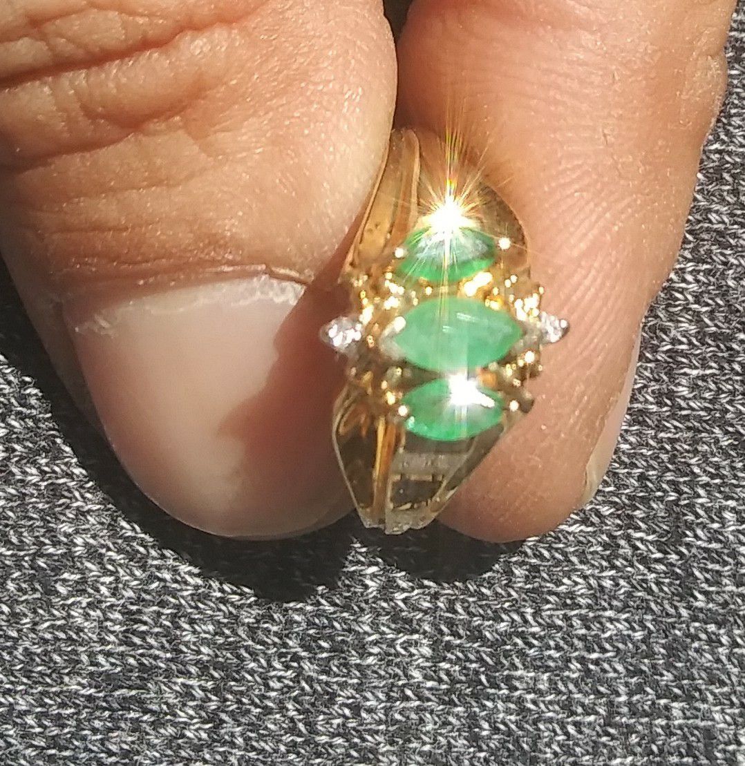 **size 7**10k Gold Ring with 2 small Diamonds and 3 Emerald stones