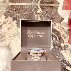 American Exchange, It Is Silver And Has A Red And Blue Strip Around The Face. One Size Fits All