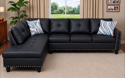 Black leather sectional couch with drop down table and ottoman