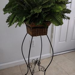 Beautiful Silk fern plant in a wicker basket and decorative metal stand
