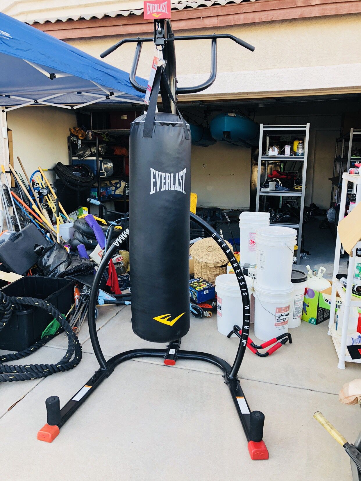 Everlast heavy bag stand with pull up and push up bars as well as 100lb heavy bag, weighted sand bags, and his & her gloves.