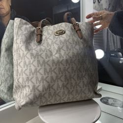 Michael Kors Jet Set Item East West Top Zip Tote bag in a signature vanilla logo-print PVC with brown leather straps and gold-tone hardware