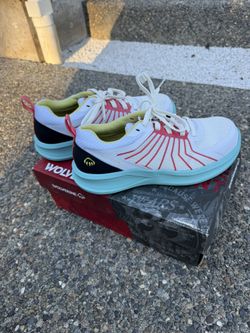 These are Wolverine DuraSpring athletic-style wor. They feature a lightweight mesh upper in white with red and black accents, a bright turquois