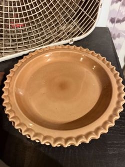 vintage tan ceramic pie plate with a scalloped edge.