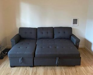 Dark Gray L-Shaped Sleeper Sectional Sofa . Dark gray sectional upholstered in a tufted, linen-look fabric.