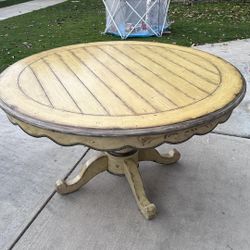 Circular dining table with fruit imprints, three chairs