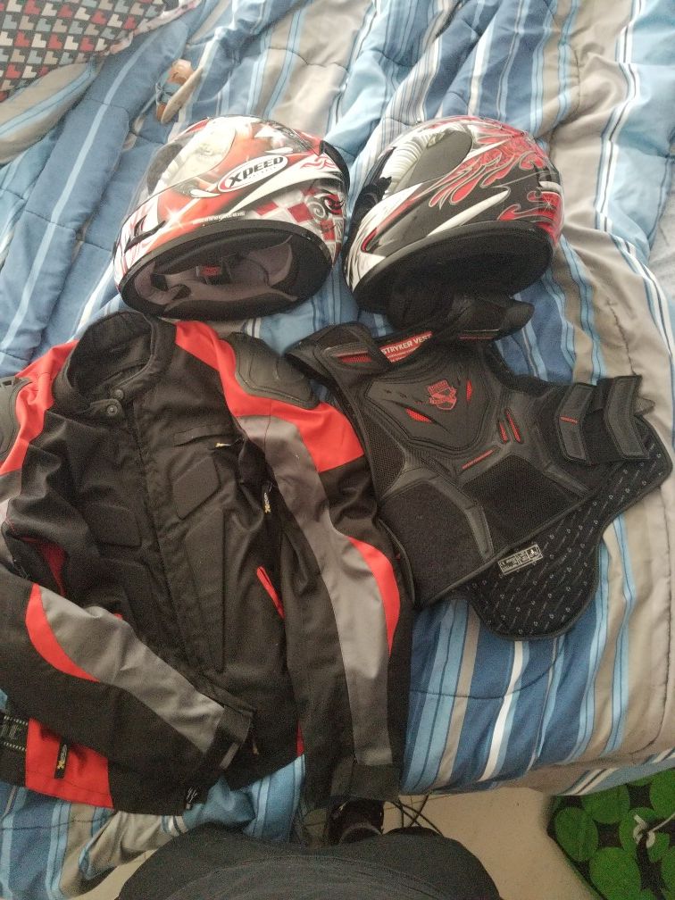Motorcycle gear red and black, two helmets jacket and chest protectir