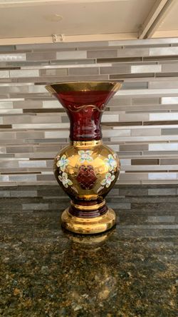Vintage Bohemian or Venetian ruby red glass vase featuring striking hand-painted floral details over a heavy gold gilt finish.