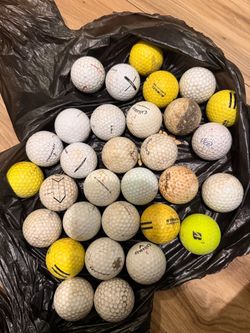 Mixed lot of roughly 30–35 used golf balls, with several brands.