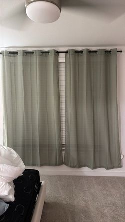 Two panel light filtering green curtains