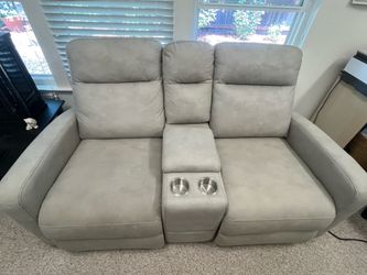 Grey Reclining Loveseat with cup holders. Inside compartment for outlets.