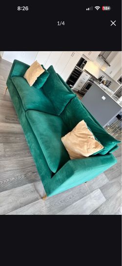 Green velvet sofa with gold accent pillows