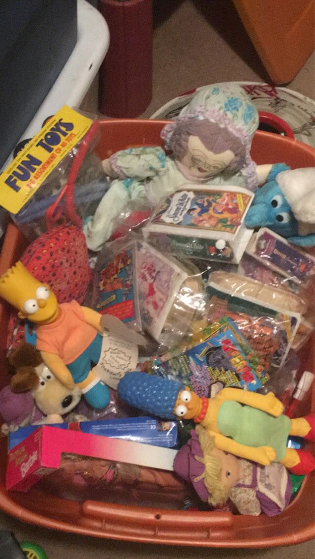 Bin filled with happy meal toys from the 90s and 2000, along with some other dolls and stuffed animals.