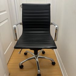 Black faux leather swivel office chair.