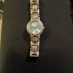 This is a vintage LA Express women's wristwatch with a silver-tone stainless steel band and a blue sunburst dial