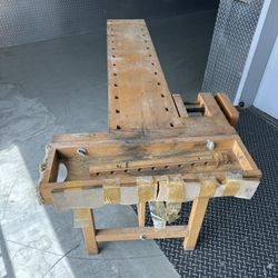 vintage Scandinavian-style wooden carpenter's workbench featuring solid wood construction, woodworking vises, and a recessed tool compartment. 