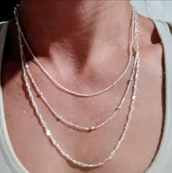 Layered Silver Chain Necklace, sterling silver earrings, and a sterling silver clasp bracelet.