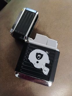 This item is an officially licensed NFL Las Oakland Raiders vintage-style windproof butane torch lighter manufactured by FSO (For Smokers Only)
O B O