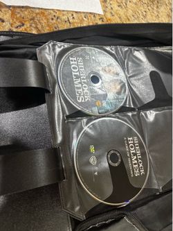 Extensive DVD collection stored in a black zippered binder. This set includes multiple discs from 'Pinky and the Brain' Volume 2 and both 'Sherlock Ho