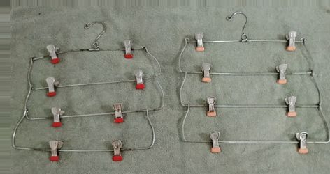 Set of 2 Metal hangers for sale with clips to hang up clothes.