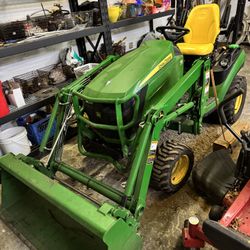 John Deere 1025R tractor with a bucket loader and backhoe I