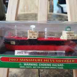 The product is a 2002 miniature Hess Voyager in its original box, a collector's item from a gas and oil theme. It is a red and black sign advertising 