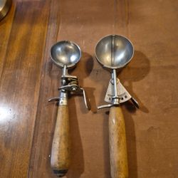 Two vintage wood handle ice cream scoops