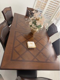 Dining table with 6 chairs brown letter and cherry wood color.