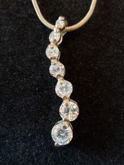 Cascading CZ pendant silvertone necklace. Necklace is 18 in. CZ pendant is 1.25 inches inches long.
