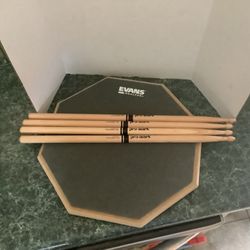 Evans 2 Sided Real Feel Practice Pad w 2 sets of sticks has gray natural gum rubber surface for realistic rebound and recycled rubber side for intense