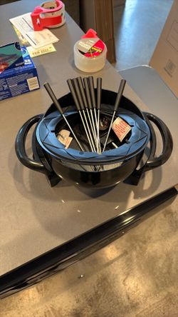 Fondue maker with sticks.