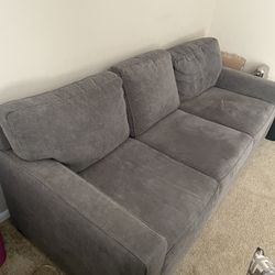 Stylish 3-seater grey couch, practically new and in excellent condition, offering both comfort and elegance