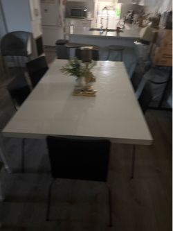 White dinning table with black chairs