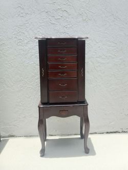 Vintage style dark wood jewelry armoire with multiple drawers and mirror