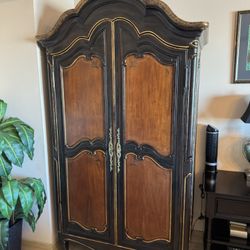 French-style armoire from Ferguson Copeland featuring a black finish with gold detailing and wood veneer panels - Retail: $3400