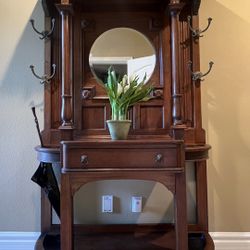 Antique Hall Tree Stand with 4 Coat/Hat Hooks, Umbrella Drip Tray & Beveled Mirror  The center has one drawer a perfect place to set your keys. It is 