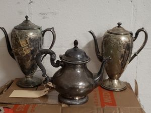 Photo The teapot on the left and right side is $10. The teapot in the middle with the wood handle is $12. All three sold separately.