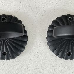 Two black cast iron wall mount candle holders
