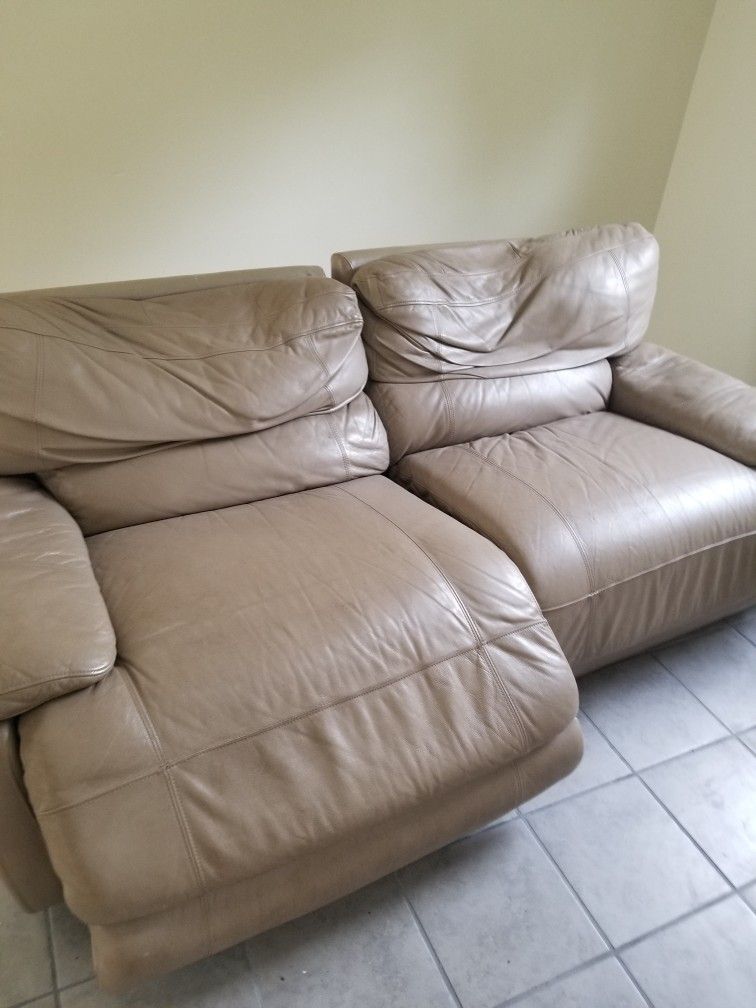 Beige Leather Electric Reclining Sofa.   One Side Reclines.  One Does Not.  Very Comfortable.  