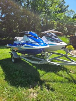 two Yamaha WaveRunner personal watercraft (jet skis/PWCs) sitting on a two-place trailer.