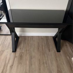 Black glass-top computer desk with X-frame legs