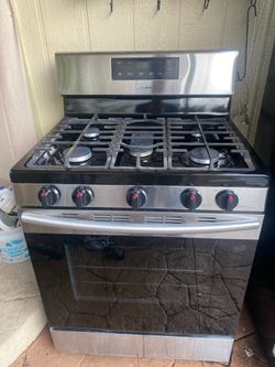 grey Samsung refrigerator and grey gas stove