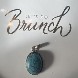 A turquoise and silver oval pendant. 