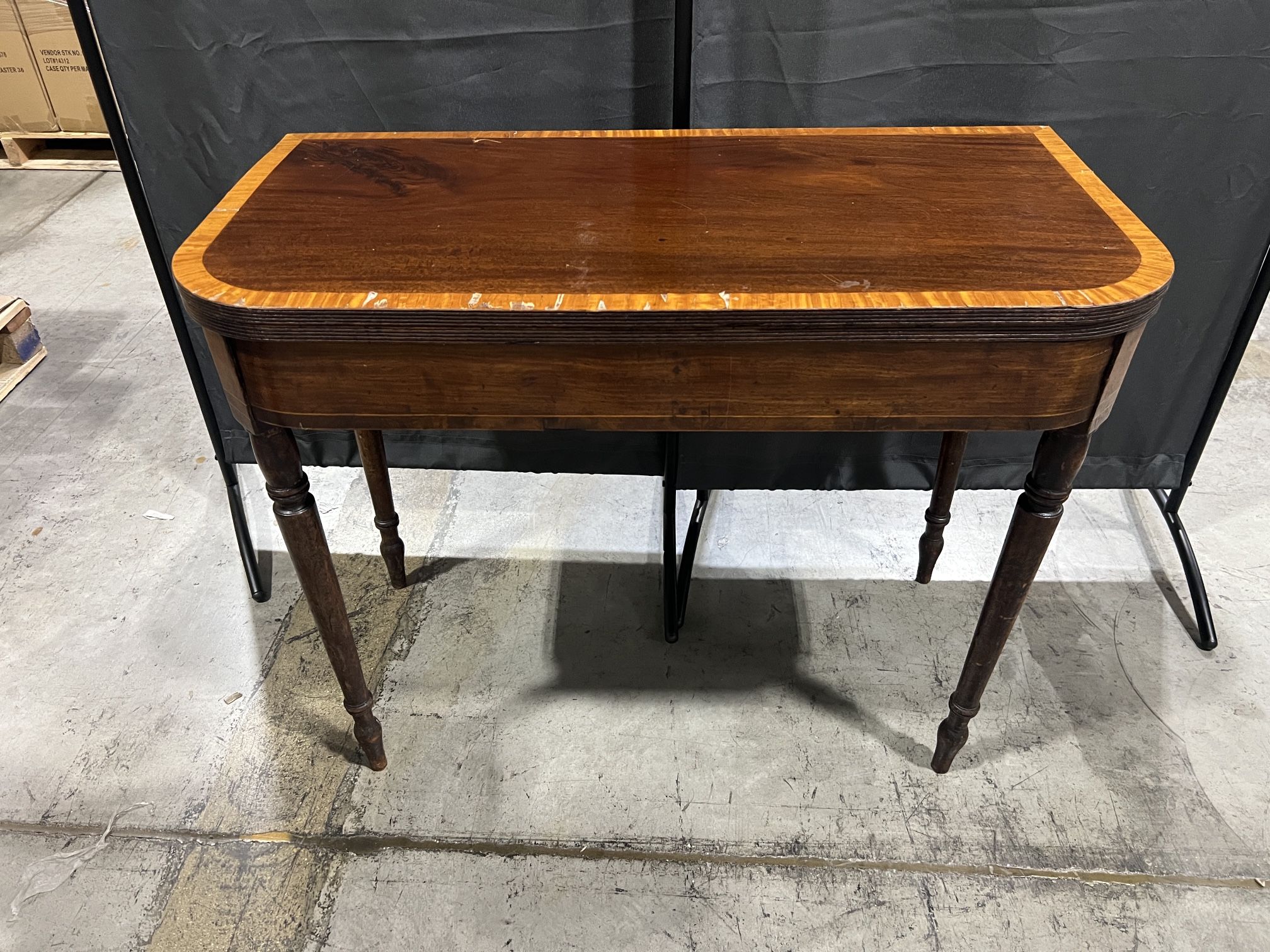 Antique Regency mahogany card table with a cross-banded fold-over top and reeded legs