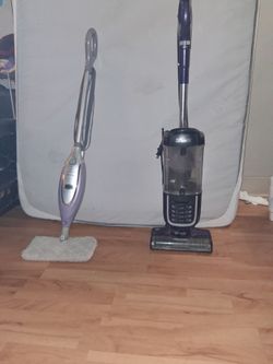 A shark vacuum in a duster , steamer and mop