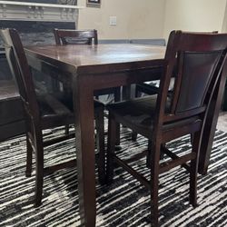 Dining Table In Dark Brown Color Made Of Wood.